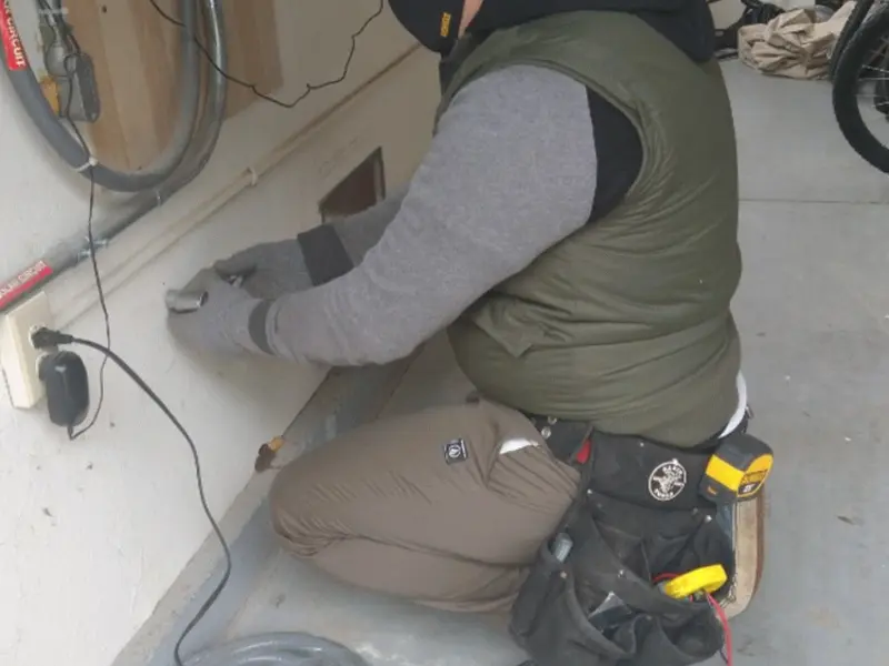Electrician performing outlet wiring in a Gypsum garage